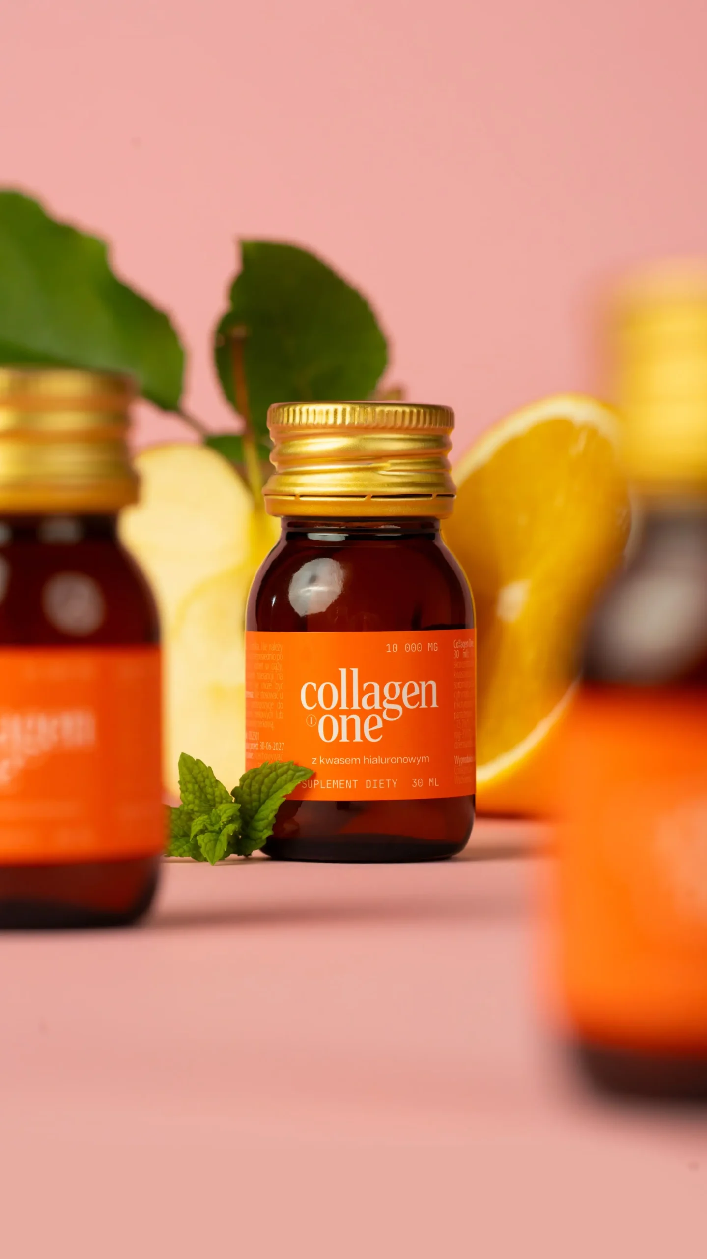 Butelki kolagenu na różowym tle, owoc cytryny na 2 planie